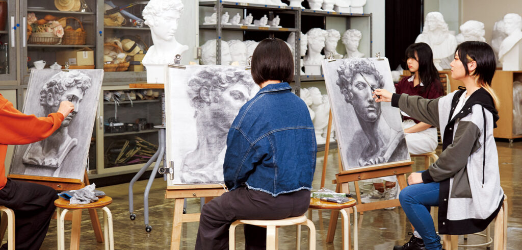 東洋美術学校の学生4人が、石膏像のデッサンに取り組んでいる様子