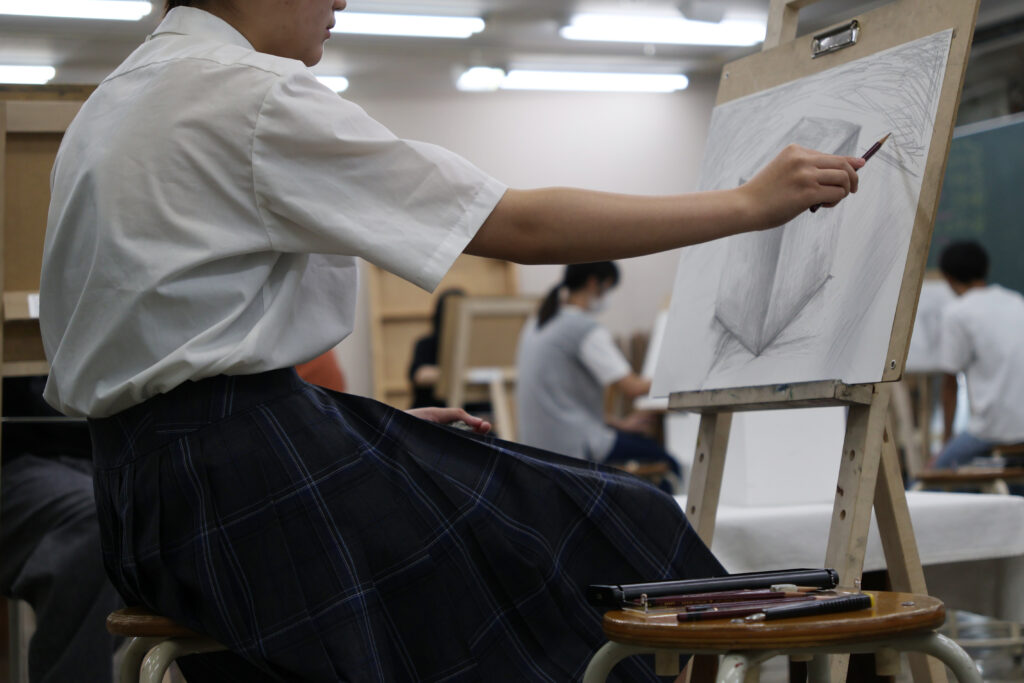 東洋美術学校の体験入学にて、立方体のモチーフの静物デッサンに取り組む高校生のみなさま