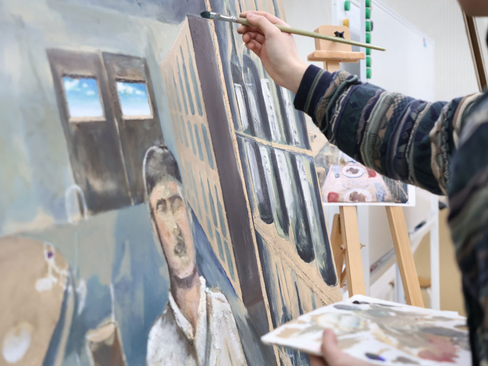 東洋美術学校絵画科の学生が、卒業制作で制作中の油彩画の着彩作業をしている。