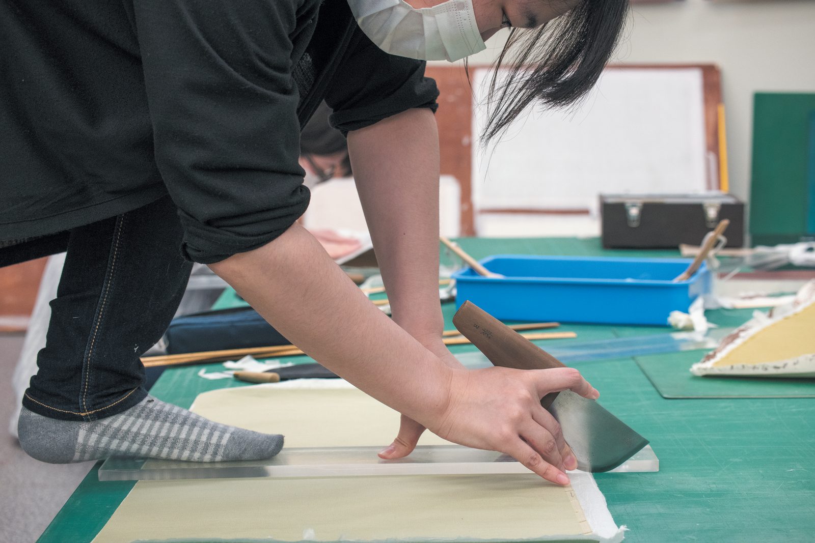 床に広げた大きな作品を扱う様子